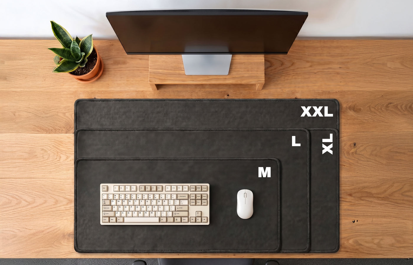 BACKSTOCK desk mat size guide showing M, L, XL and XXL mats on a timber desk