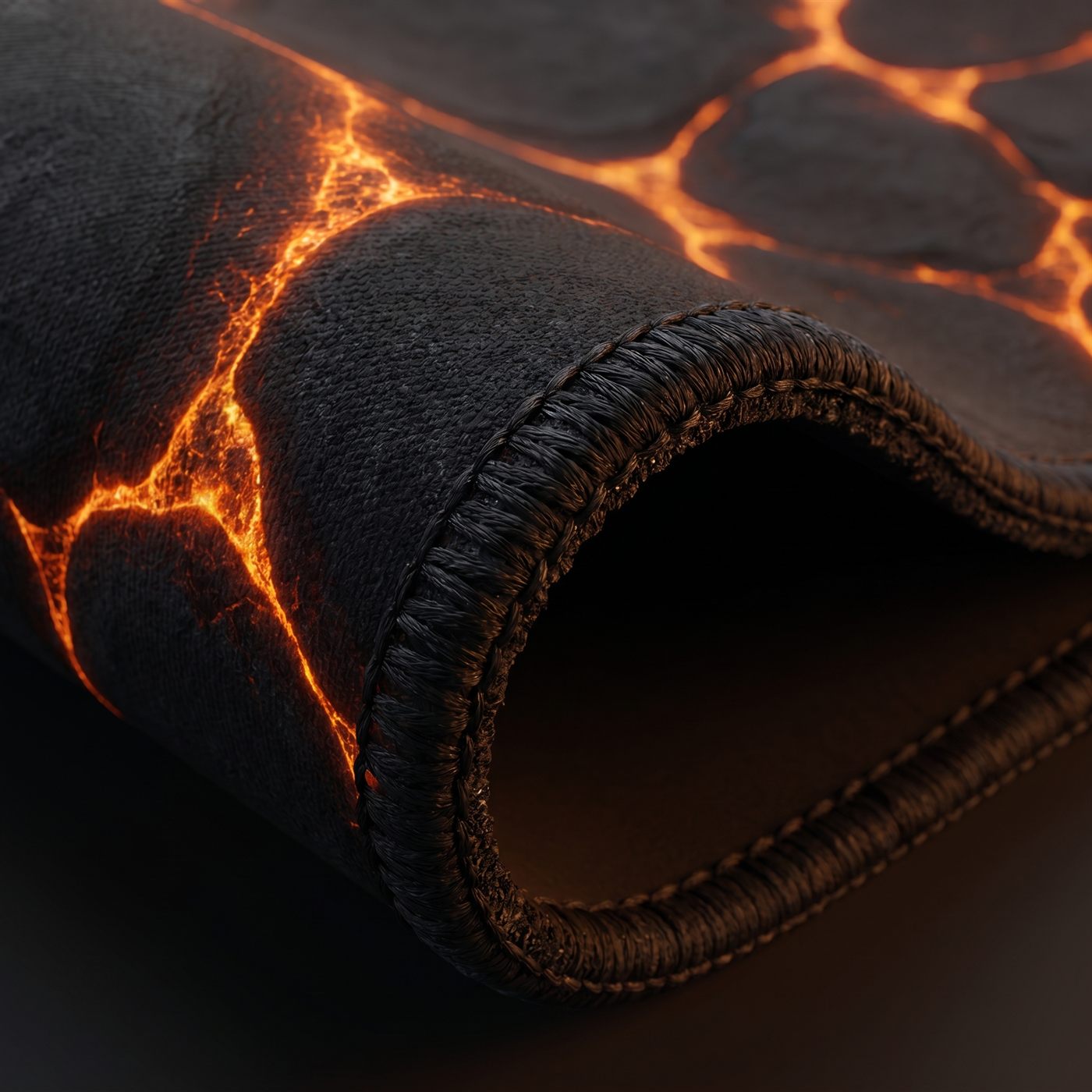 Close detail of a BACKSTOCK desk mat showing the overlocked stitched edge and non-slip rubber base